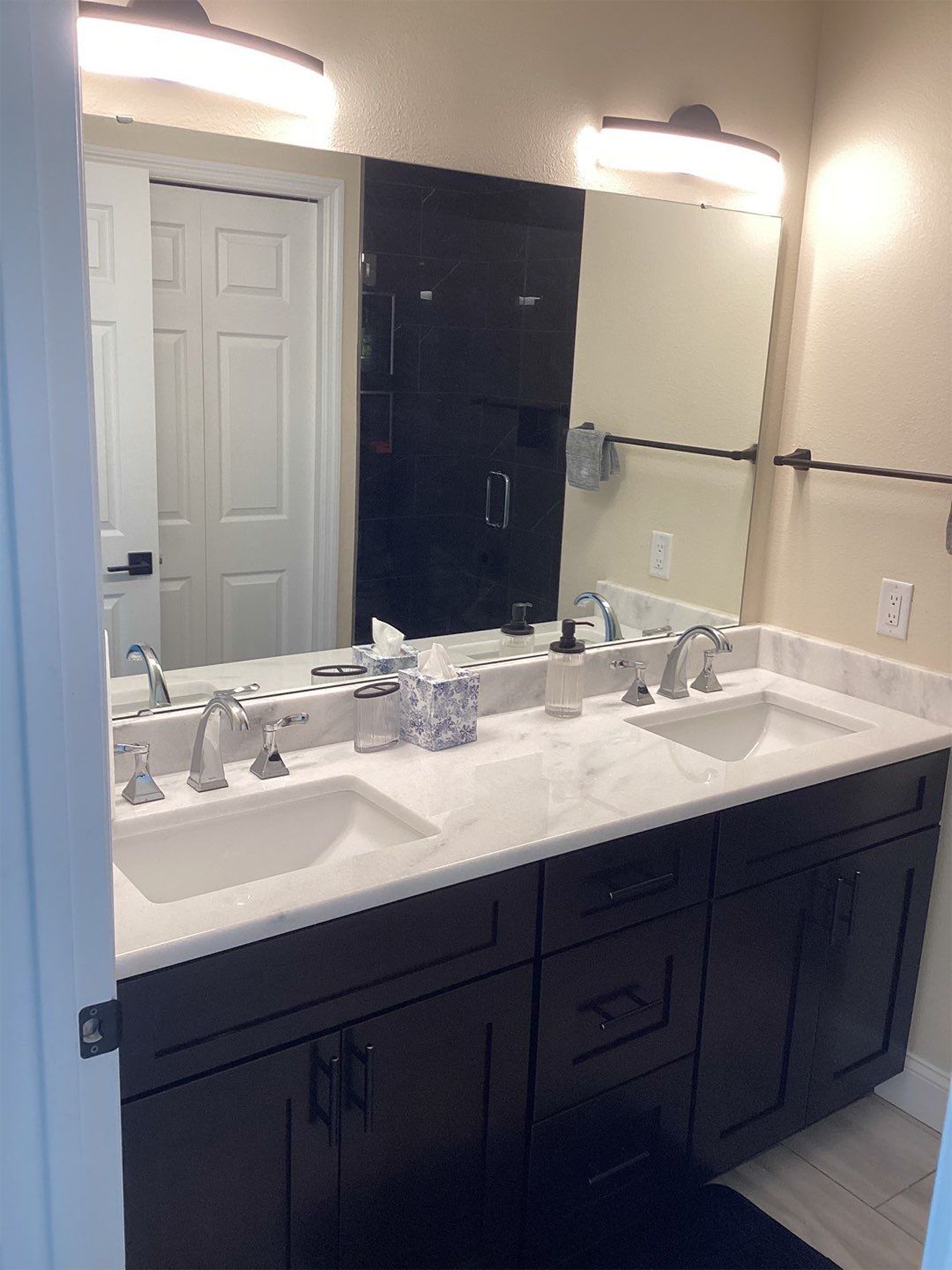 A bathroom with two sinks and a large mirror