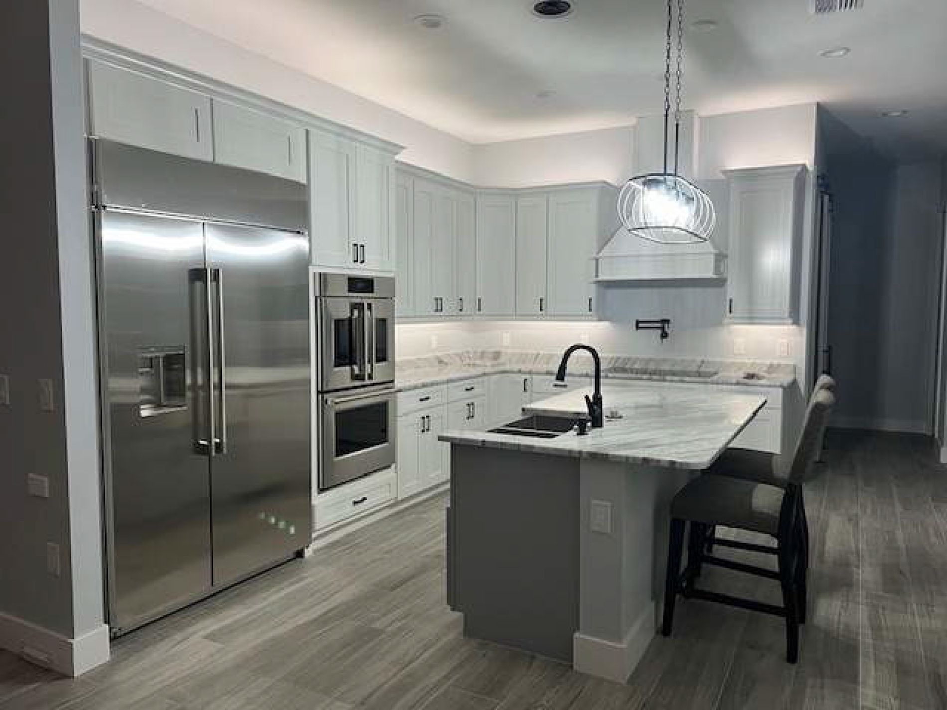 A kitchen with stainless steel appliances and white cabinets.