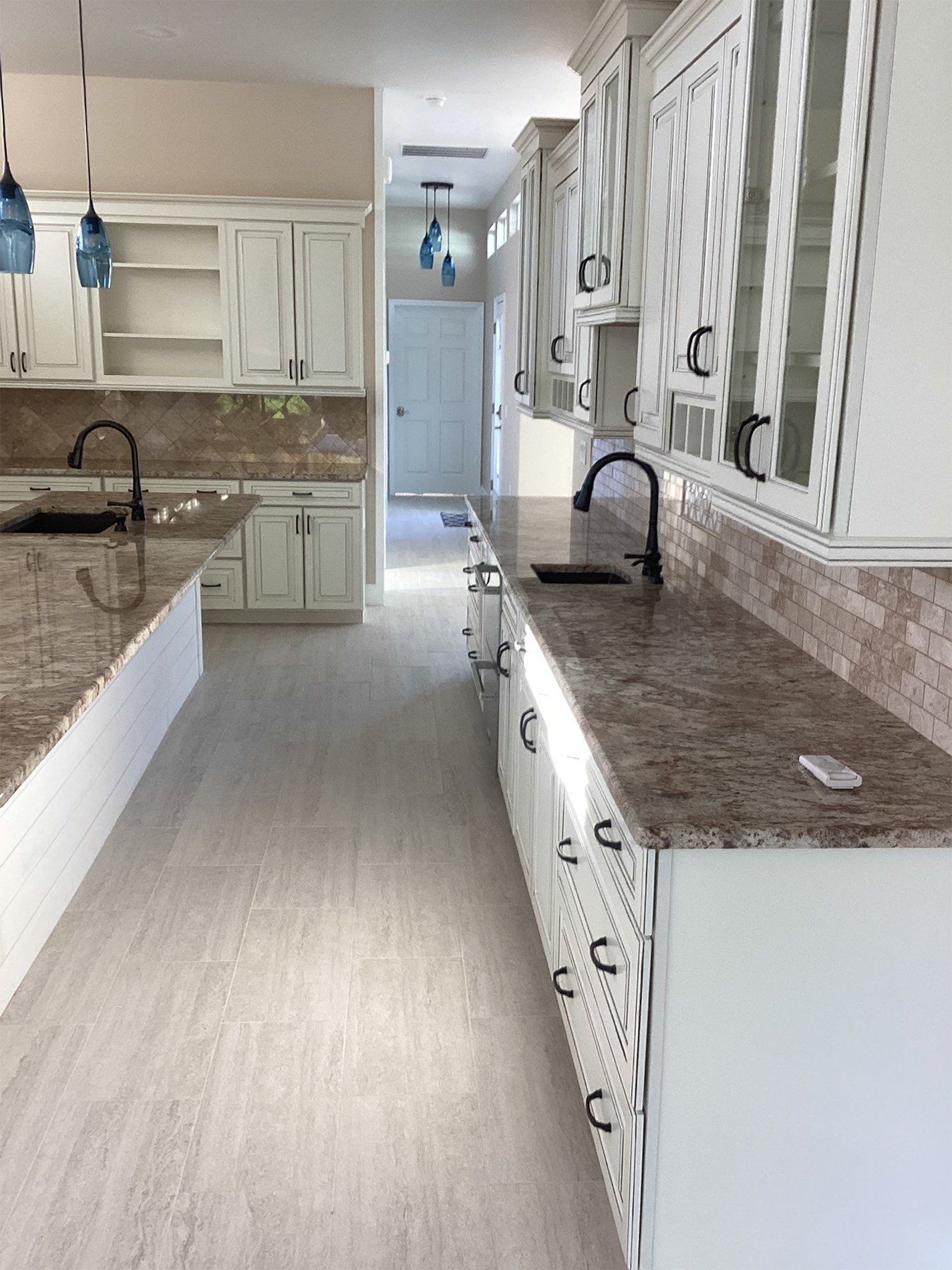 A kitchen with white cabinets and granite counter tops.
