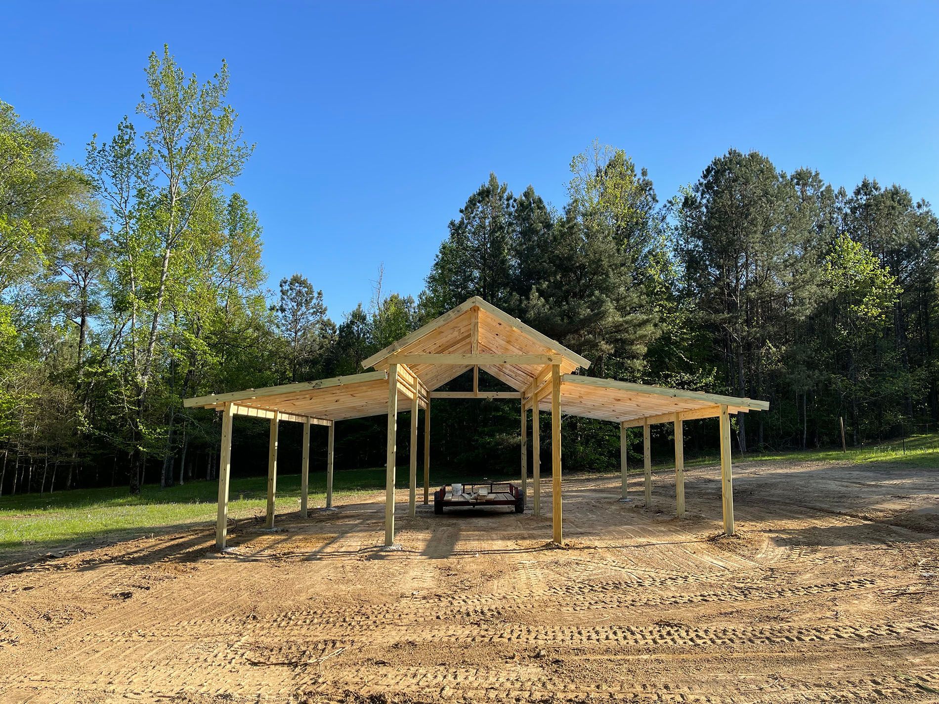A wooden structure is being built in the middle of a dirt field.