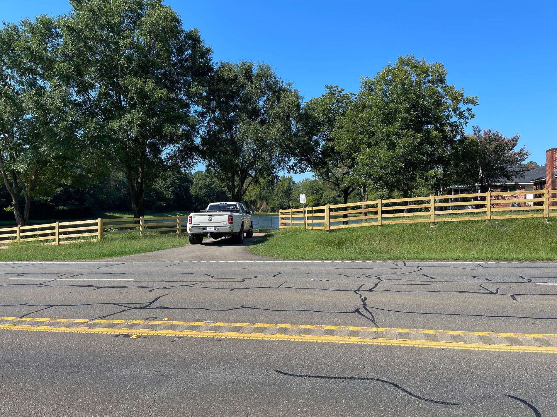 A truck is driving down a road next to a wooden fence.