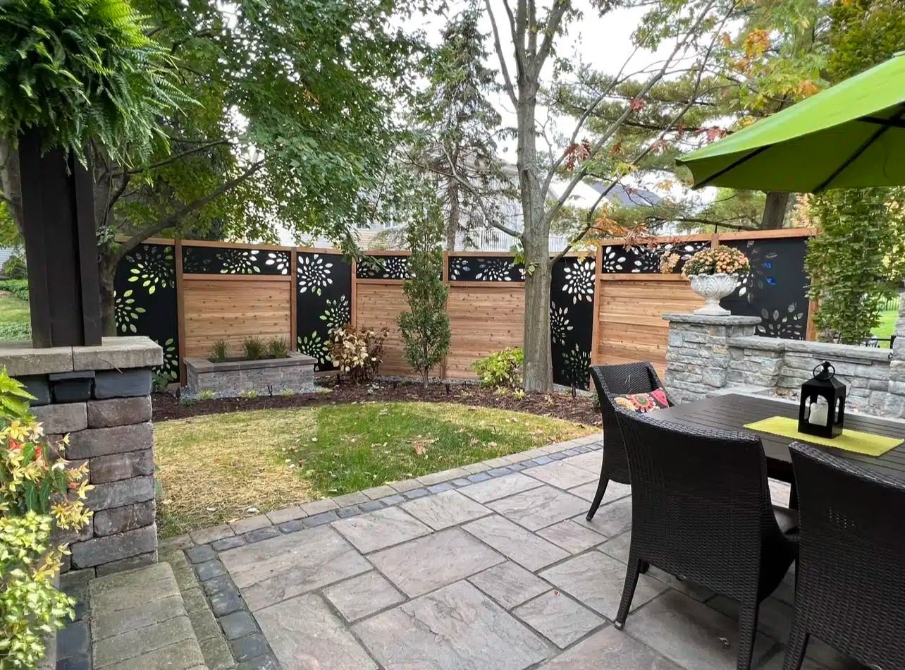 Backyard patio with wooden fence, decorative panels, and outdoor furniture.
