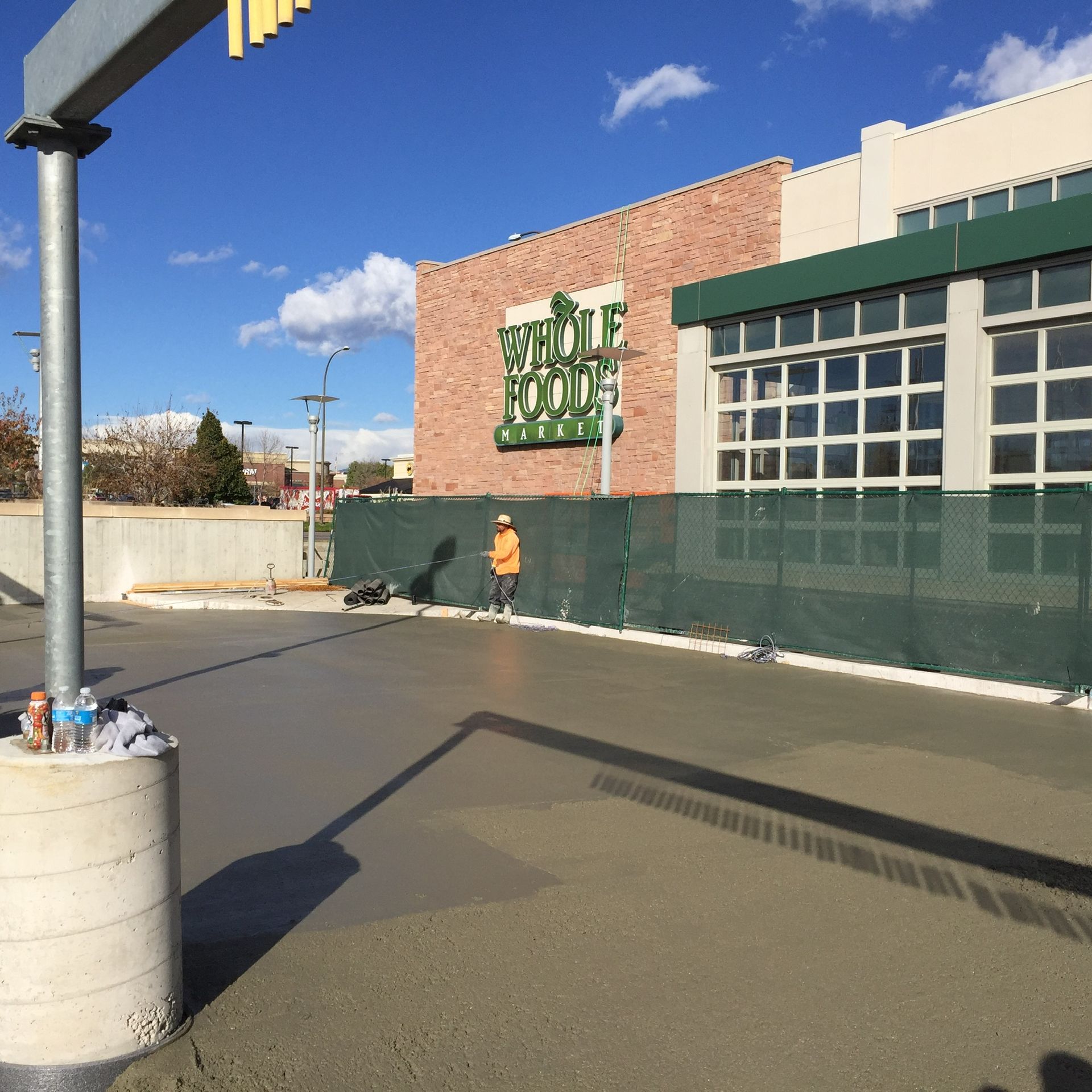 A group of construction workers is working on a sidewalk in front of a building.