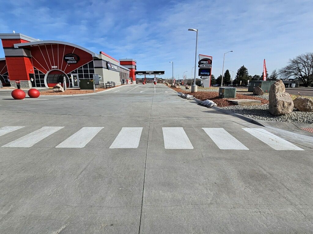 A road with a crosswalk in front of a building.
