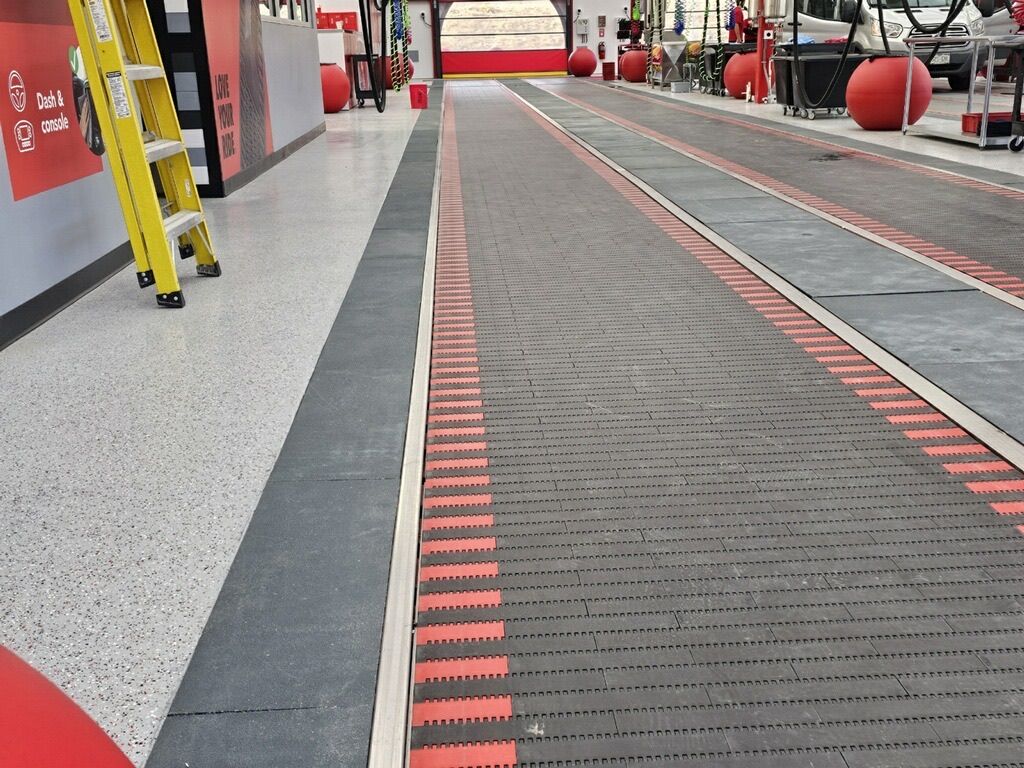A road with a crosswalk in front of a building.
