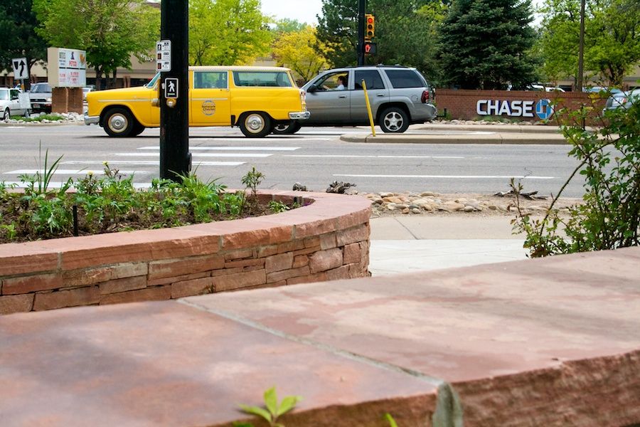 A yellow car is driving down a street in front of a Chase bank.