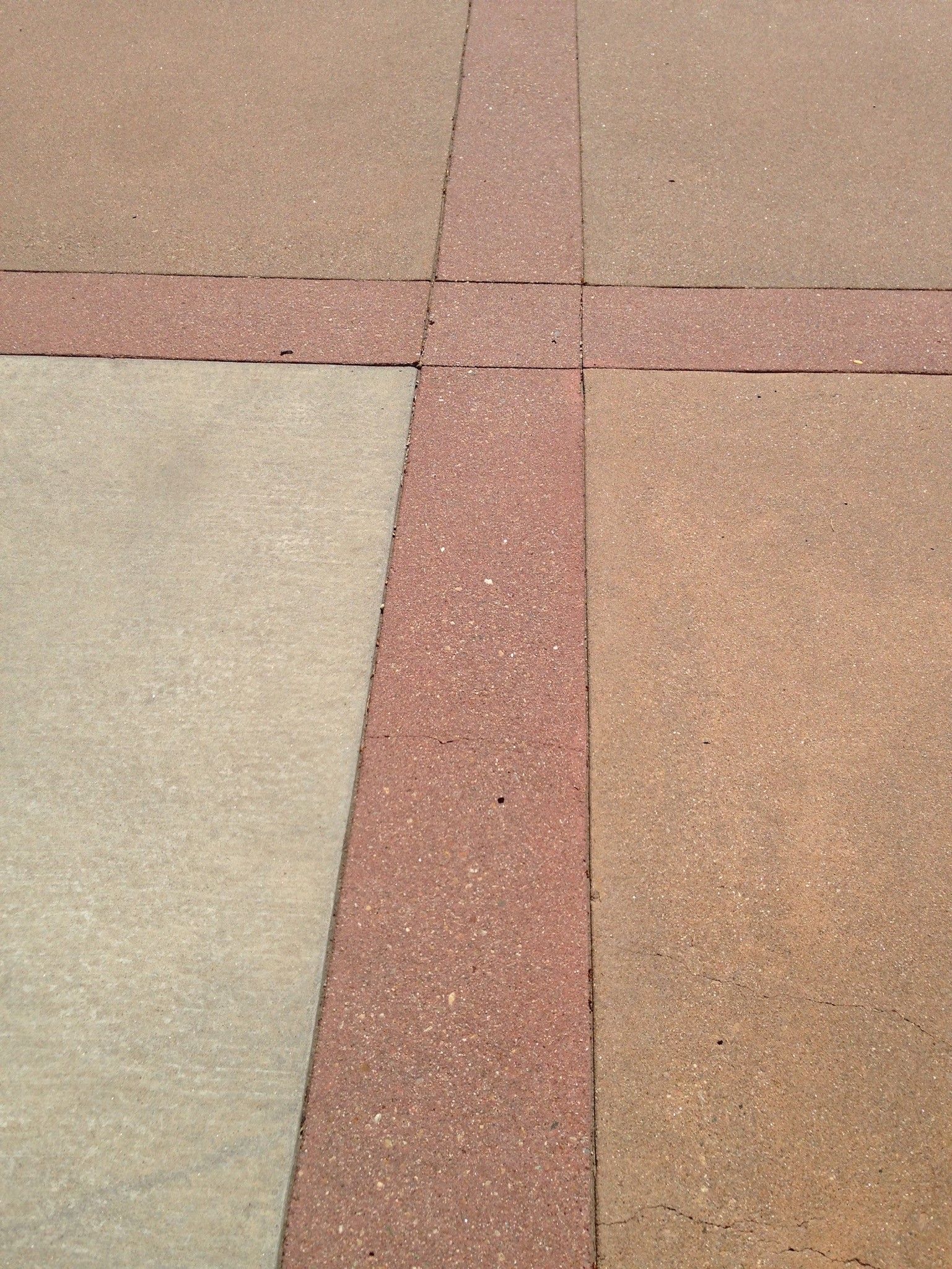 A close up of a brick walkway with a cross in the middle.
