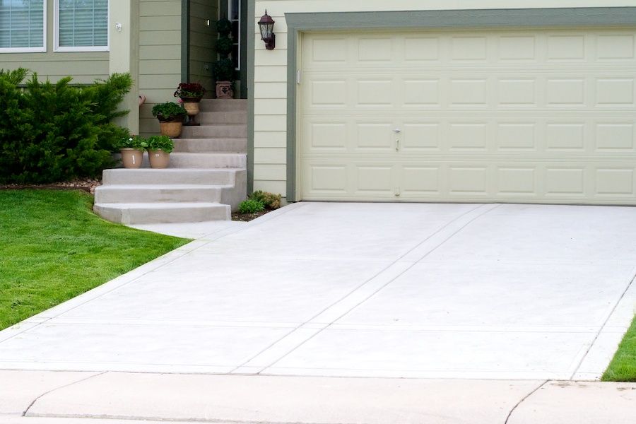 A white garage door is open in front of a house.
