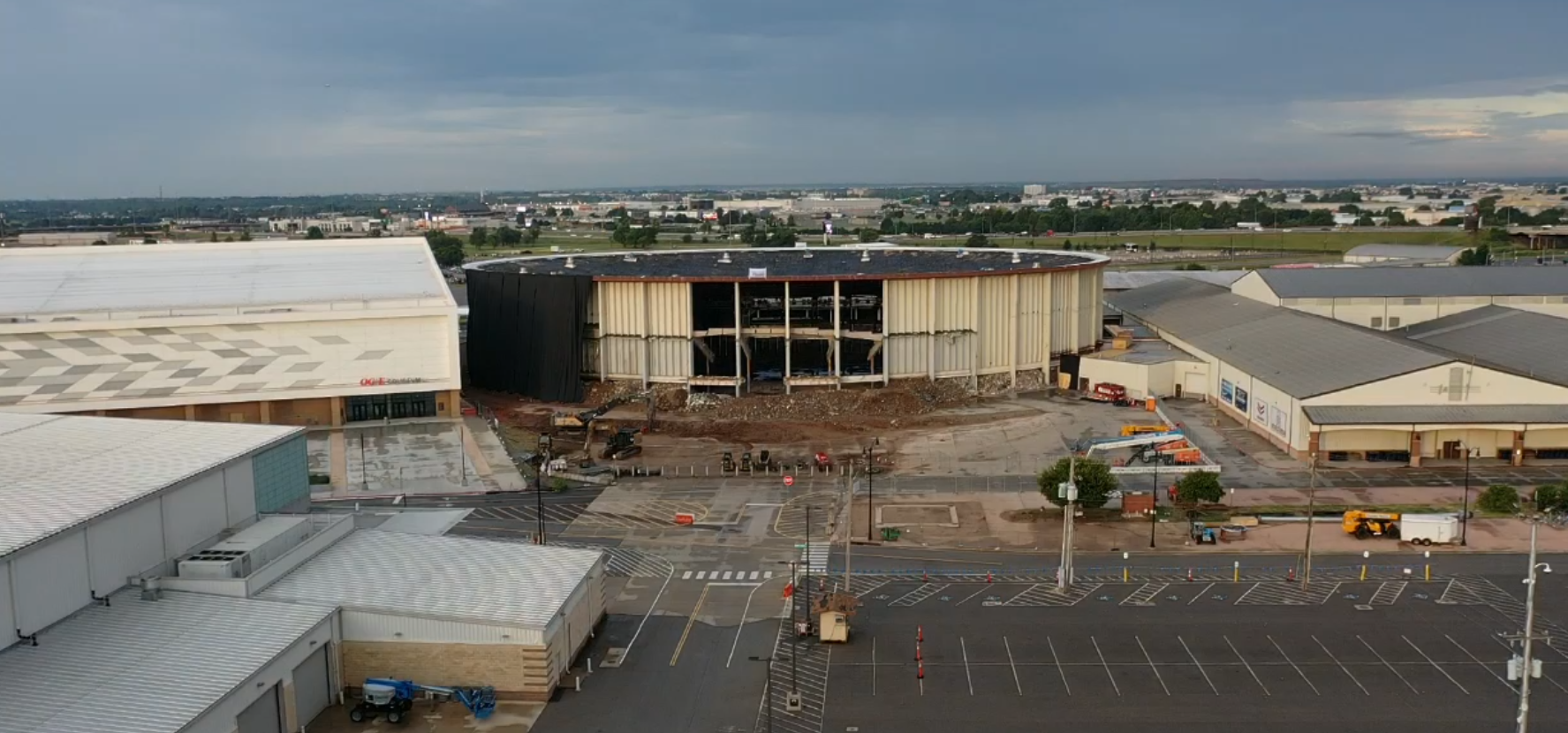 Aerial view of a damaged shopping center with collapsed facade and empty parking lot