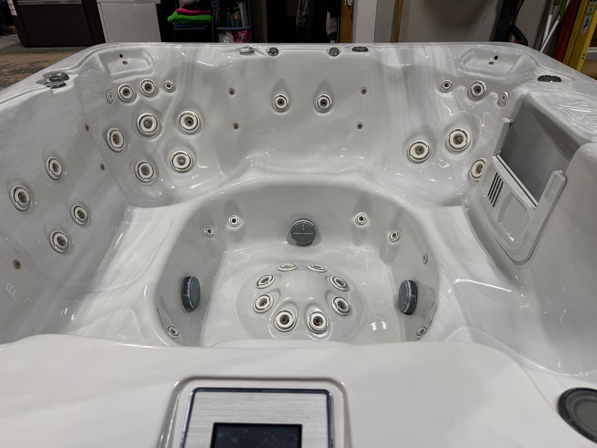 White hot tub with multiple jets and control panel.