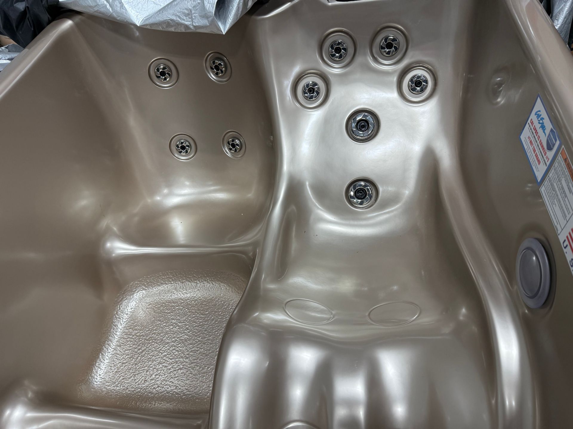 Tan-colored hot tub interior with multiple jets.