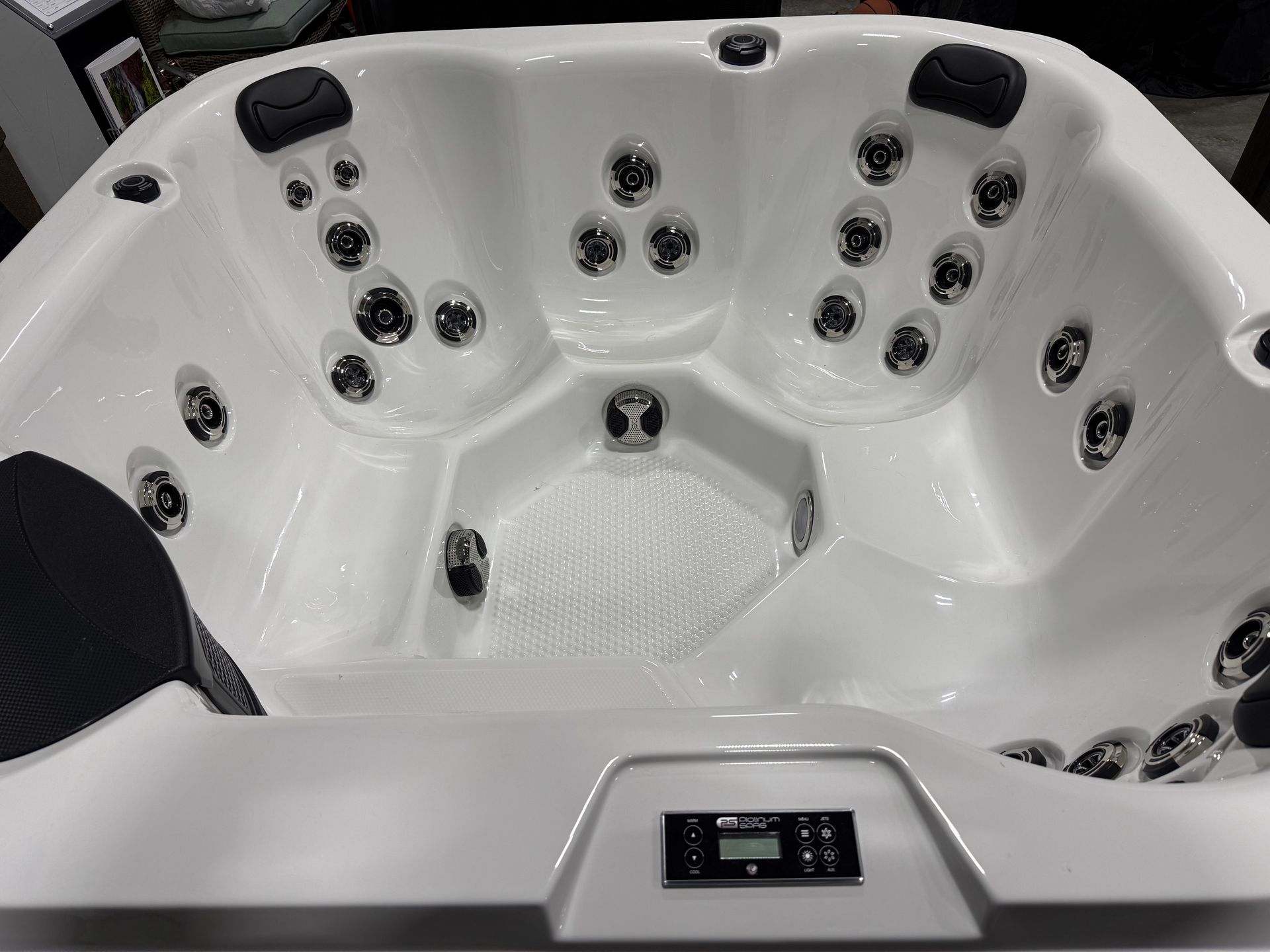 White hot tub with multiple jets and digital control panel.