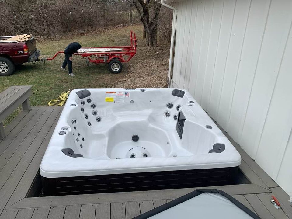 A hot tub installed in a deck cutout, a person pulls a cart.