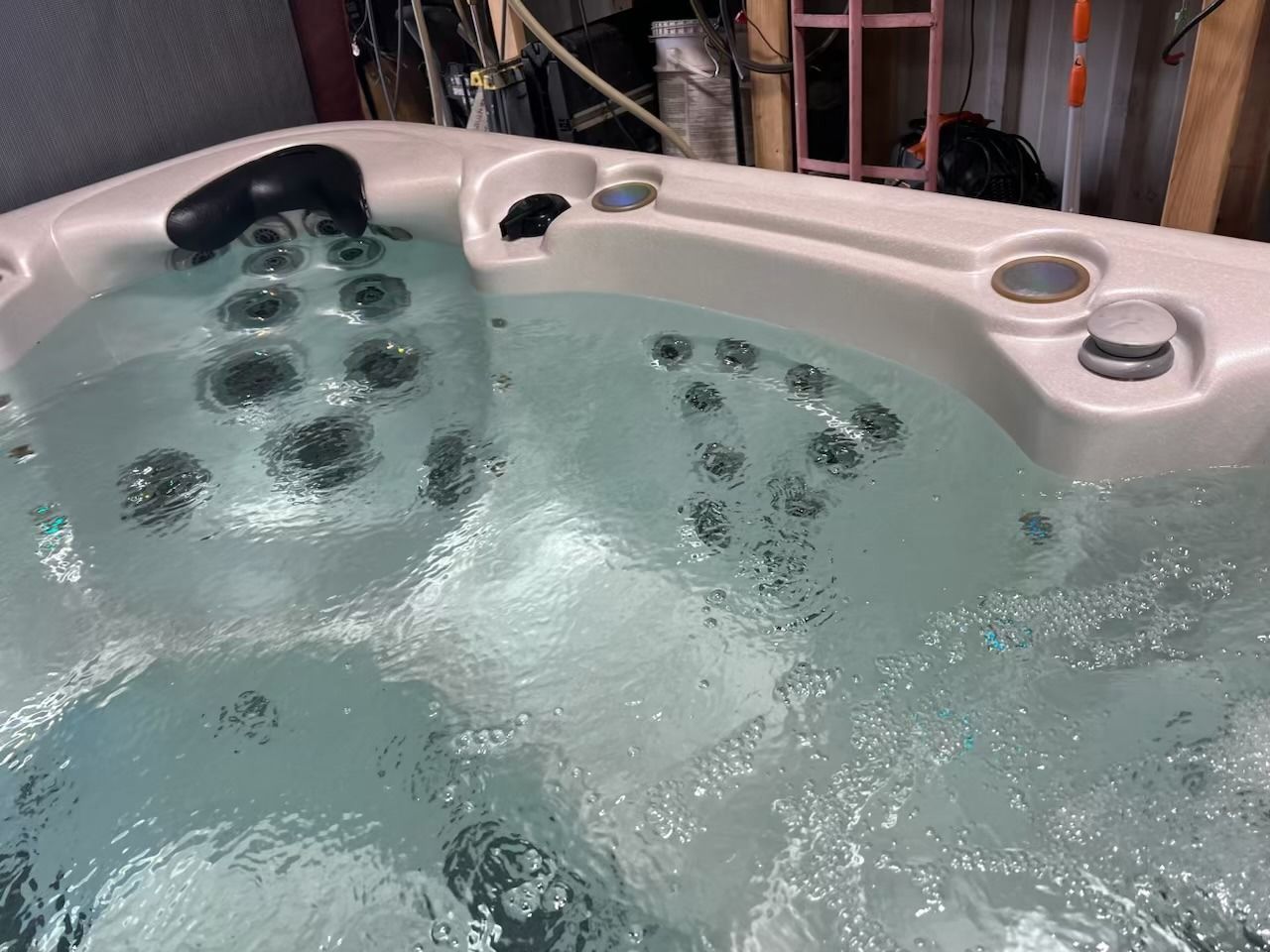 Hot tub filled with bubbly, clear water; jets visible.