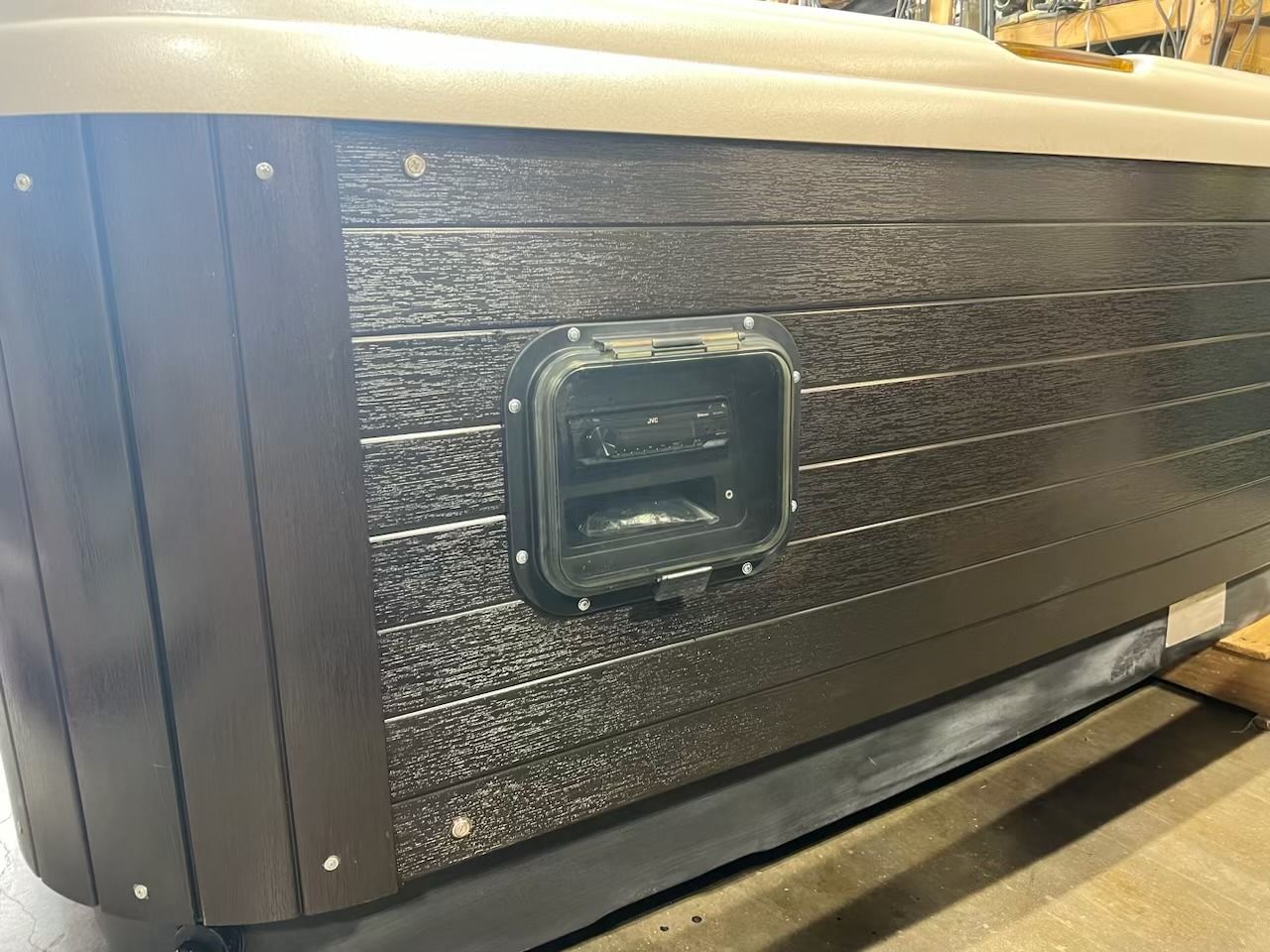 Dark brown hot tub exterior with a control panel and light-colored top.
