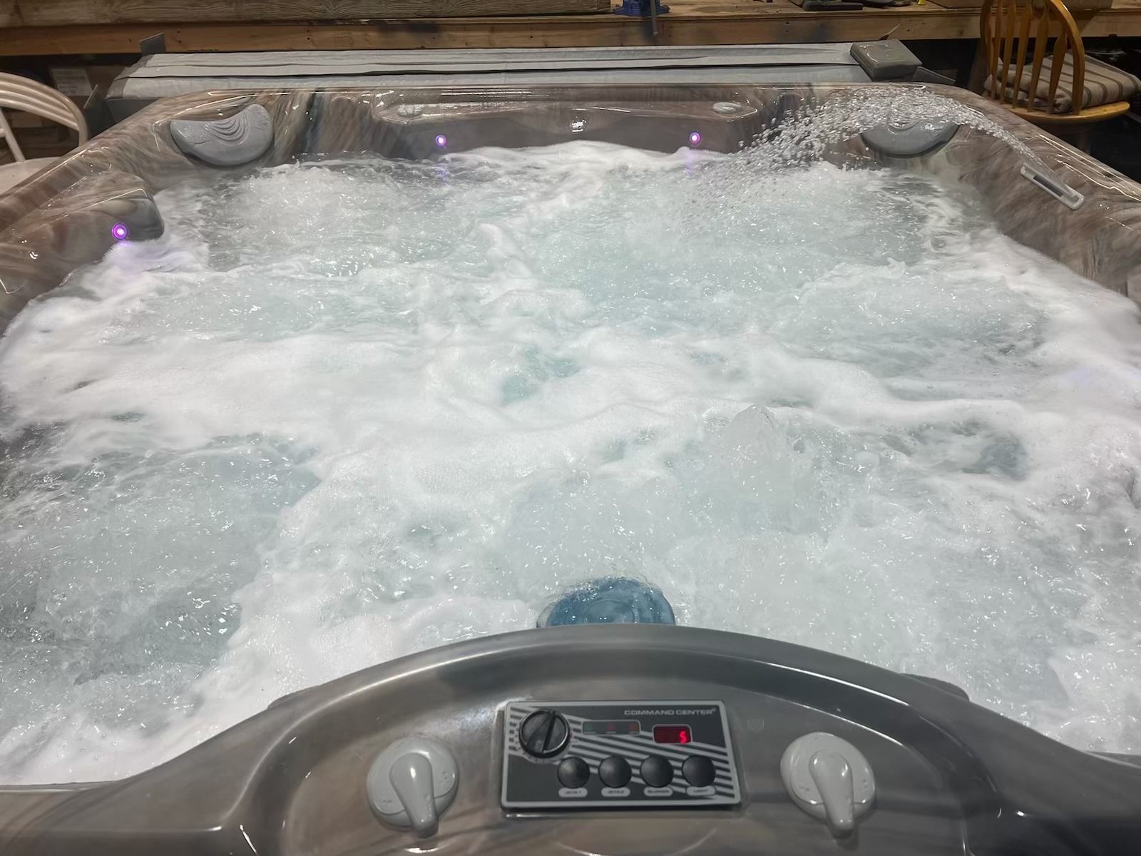Hot tub with bubbling water and control panel.