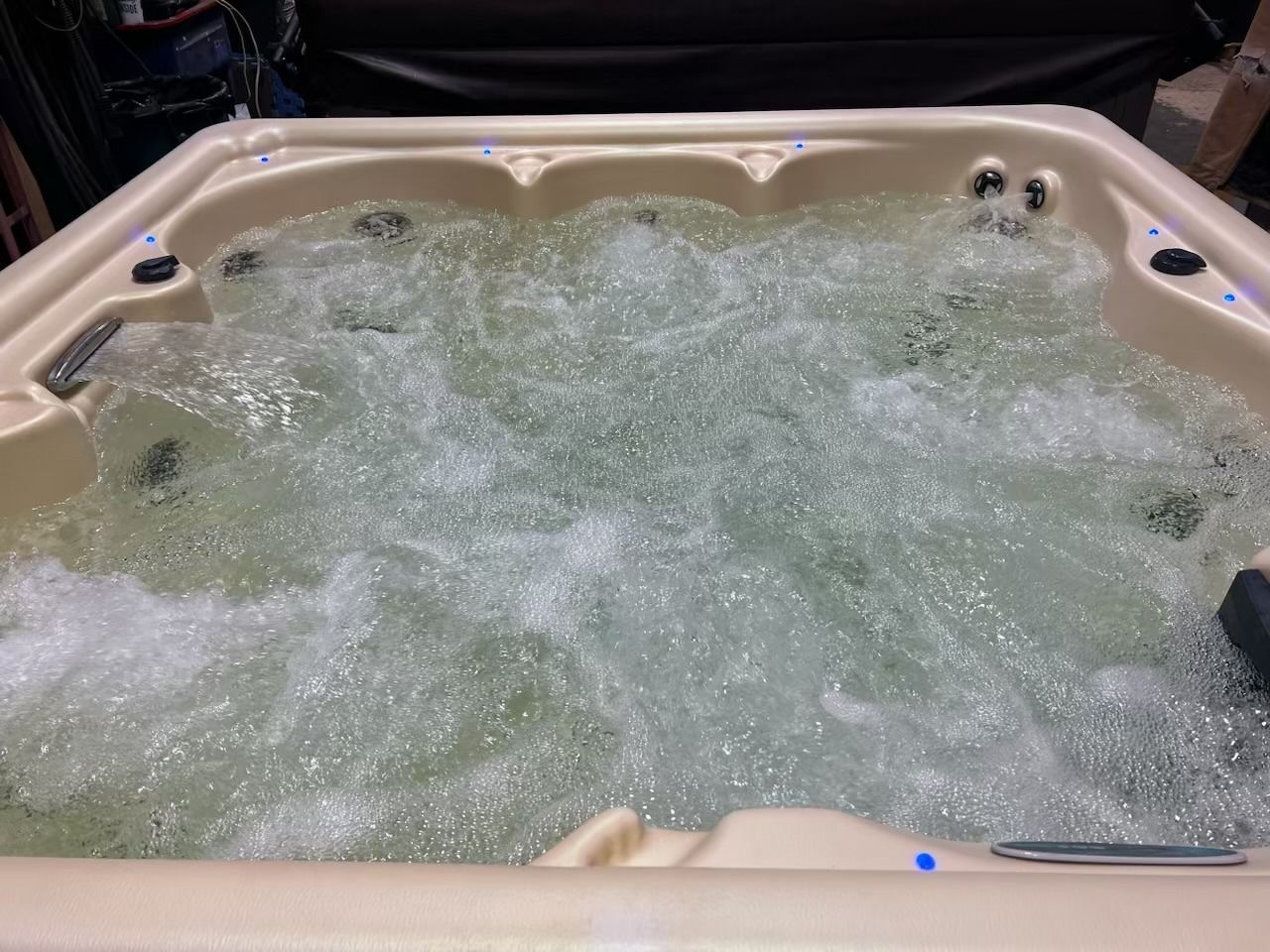 Hot tub filled with bubbly water, beige interior.