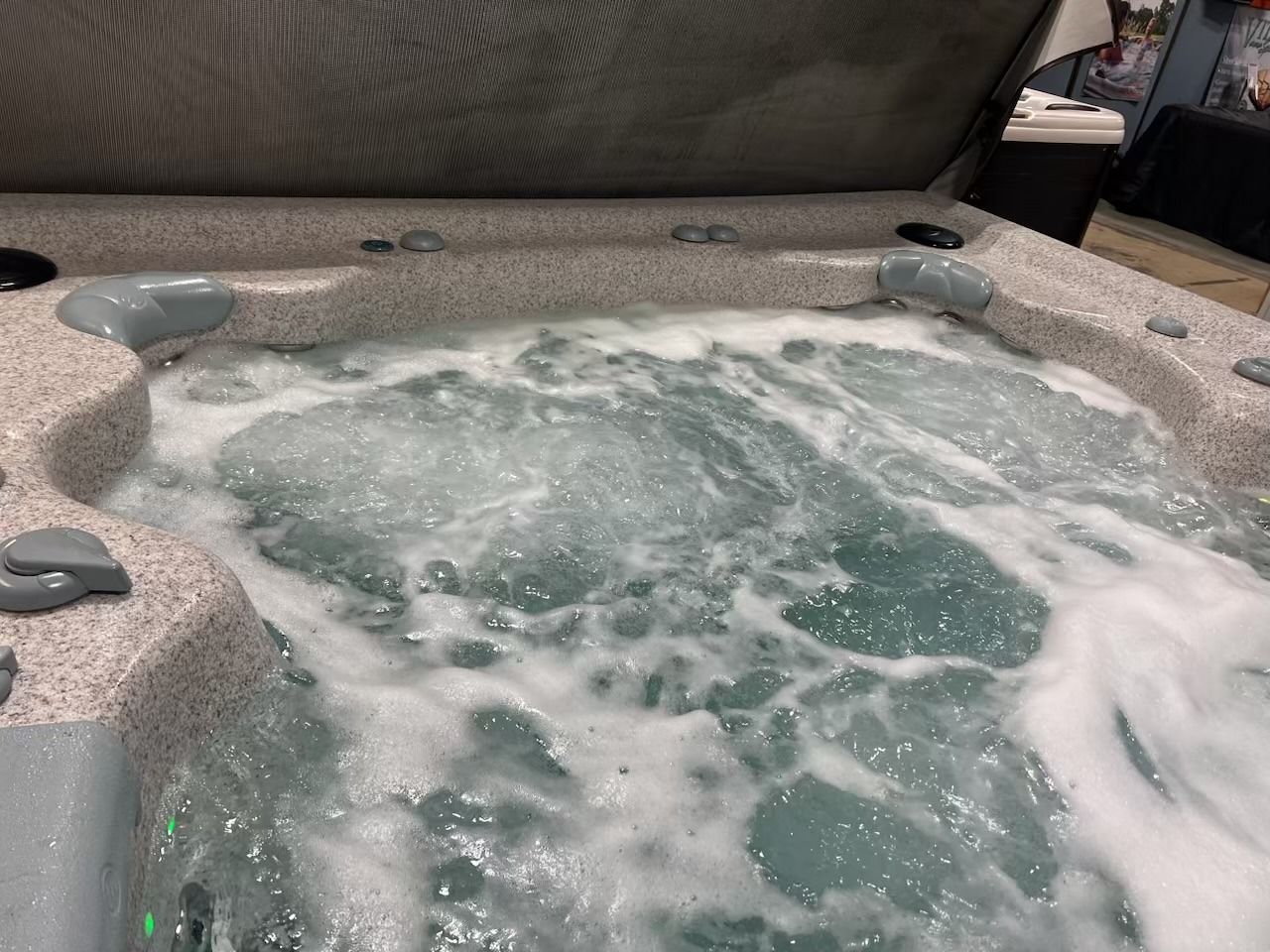 Hot tub with bubbling water and gray surround.