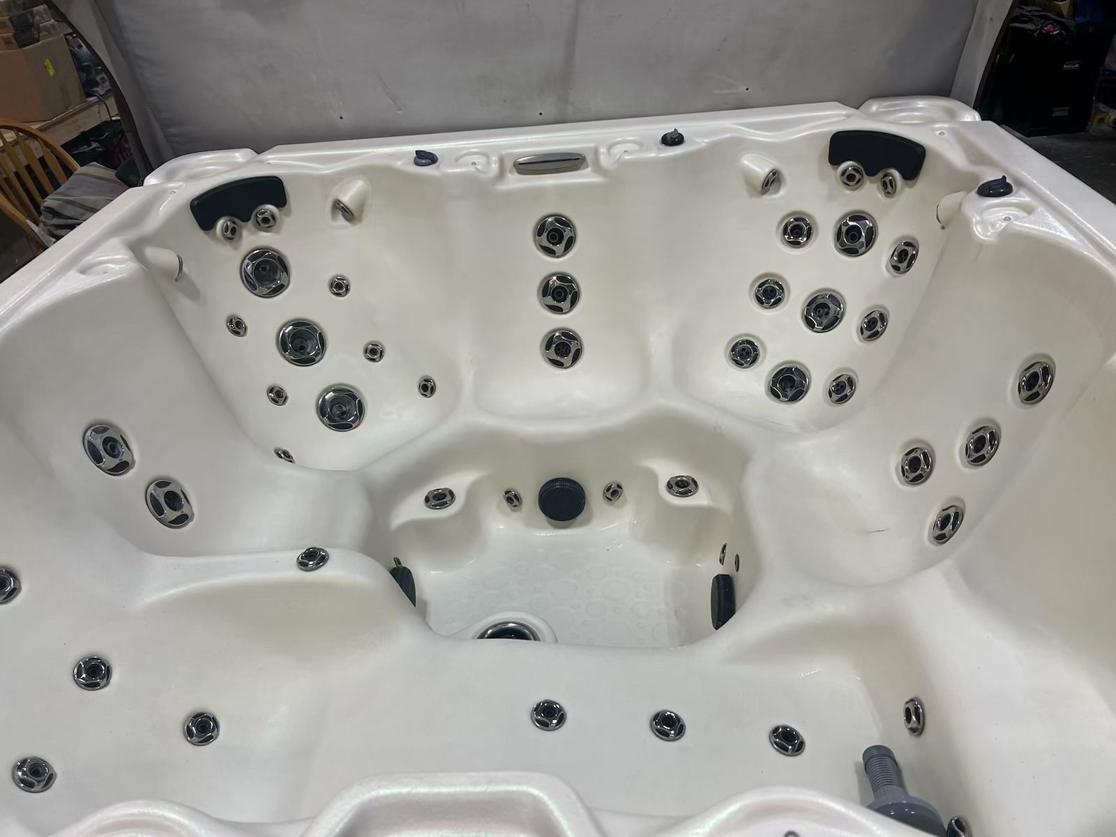 White hot tub interior with multiple jets, open lid.