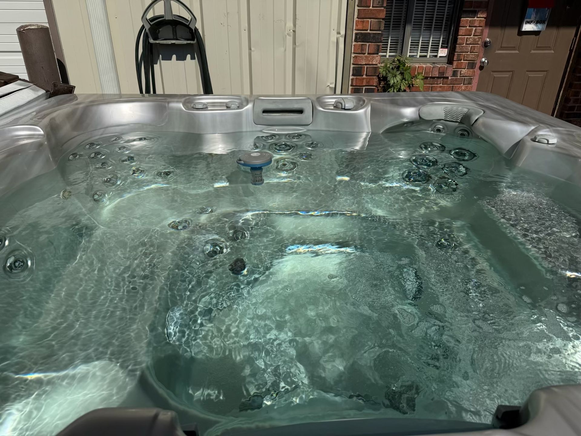 Bubbling hot tub with clear water, outdoors.