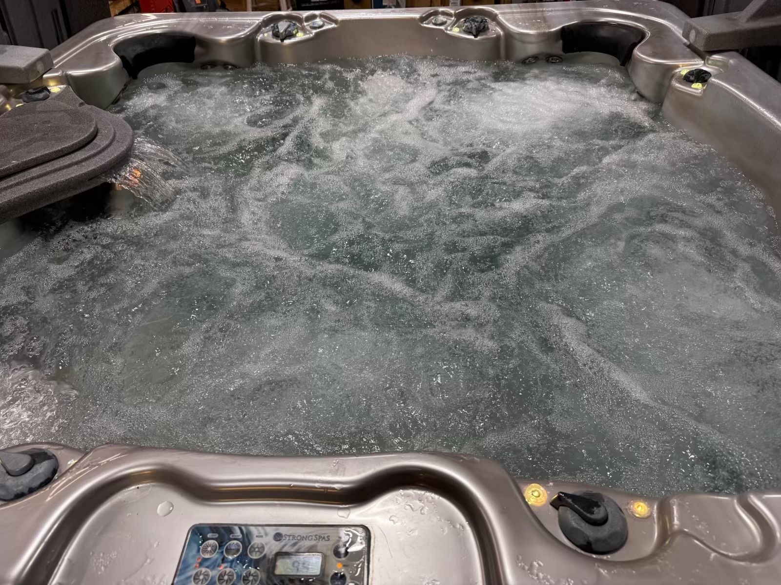 Bubbling hot tub with control panel and jets.