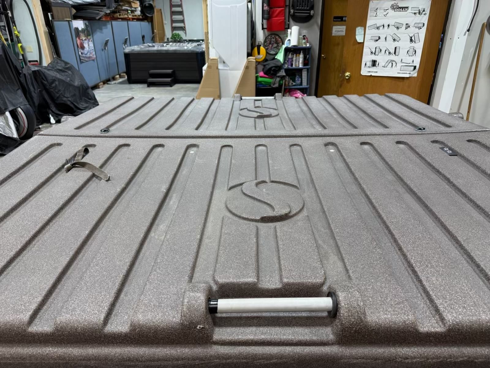 Gray textured rectangular storage container lids with handles, outdoors setting.