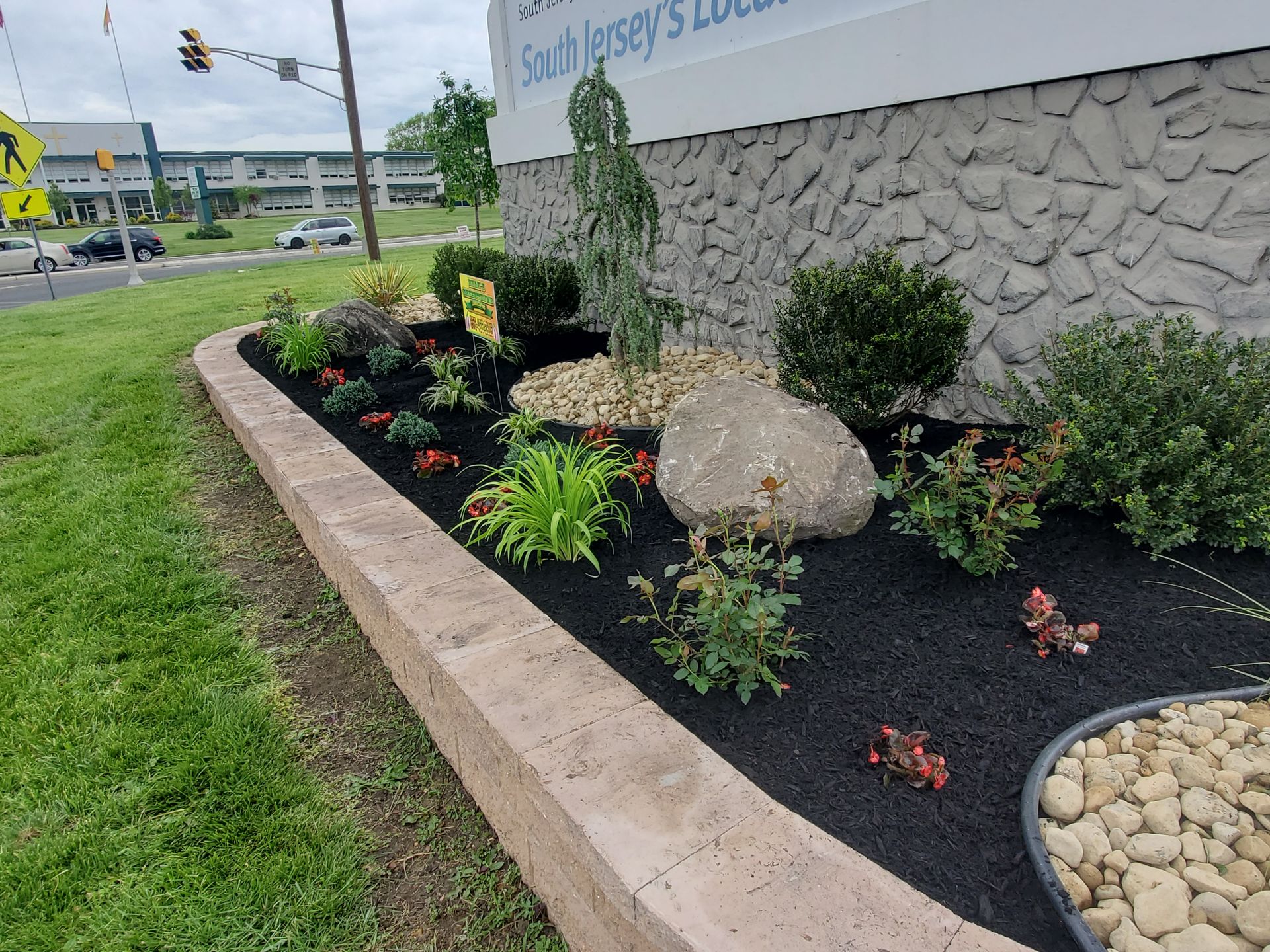 A garden with rocks and plants in front of a building.