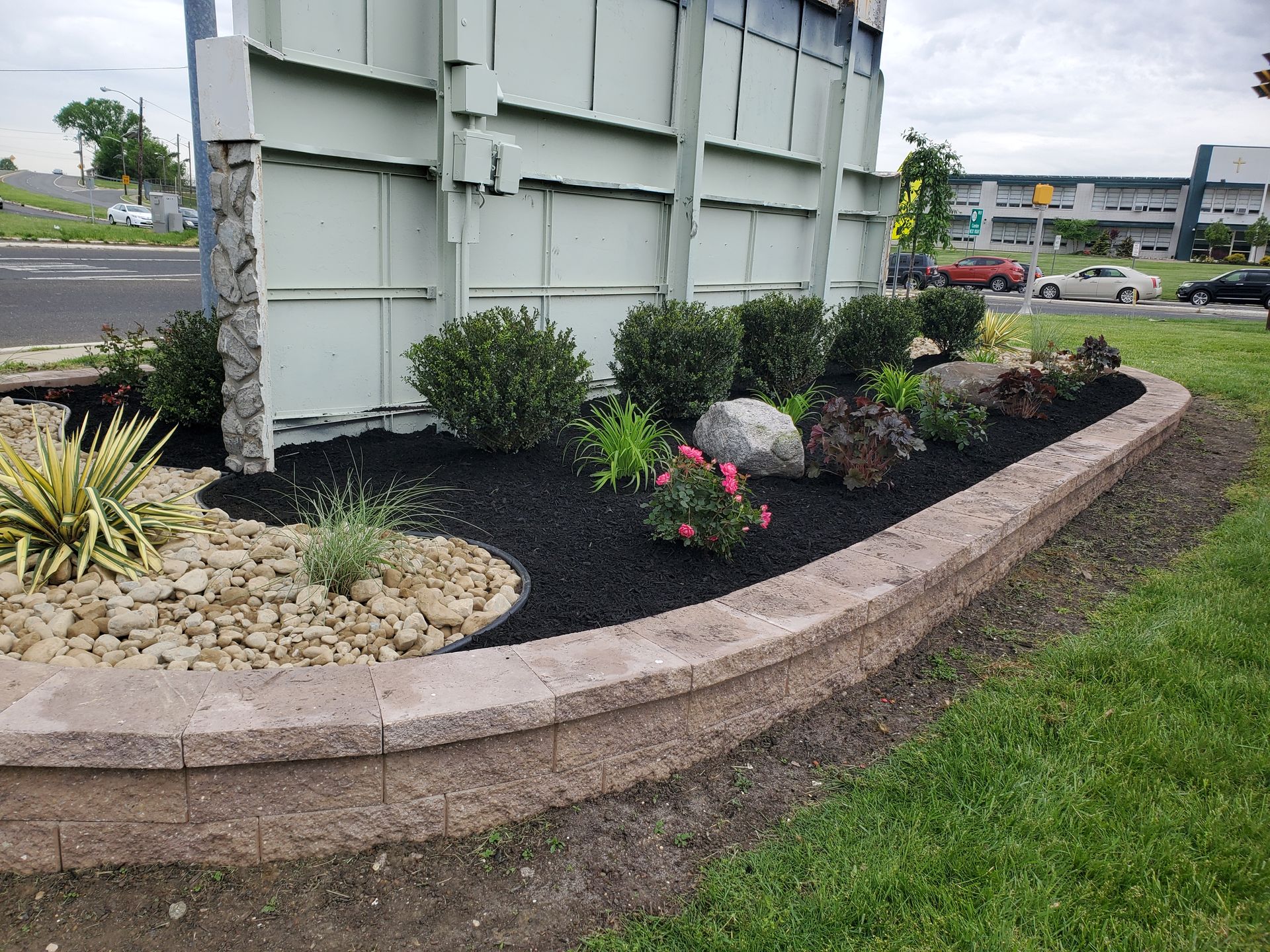A garden with flowers and rocks in front of a building.