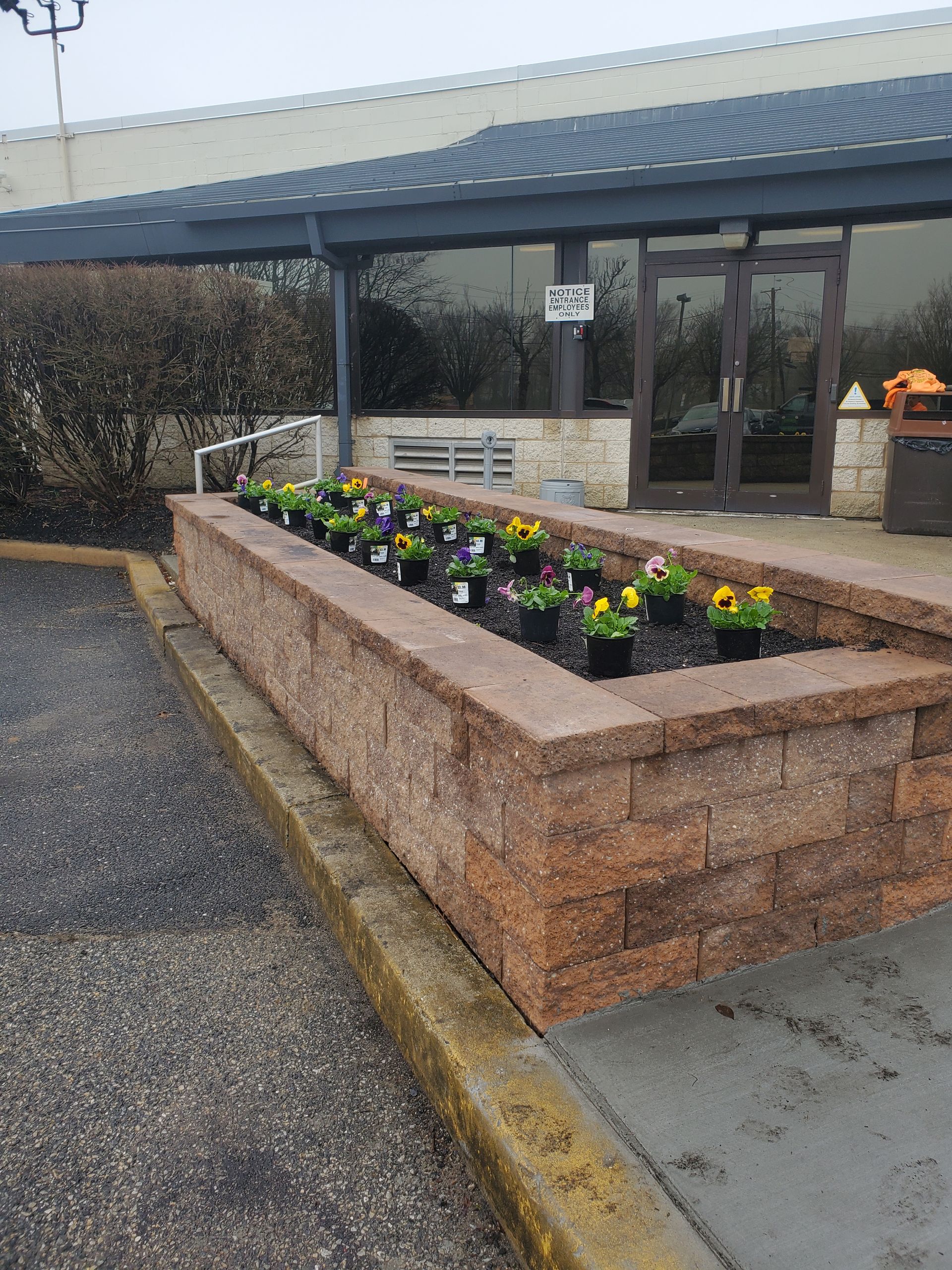 A brick wall with flowers in front of a building