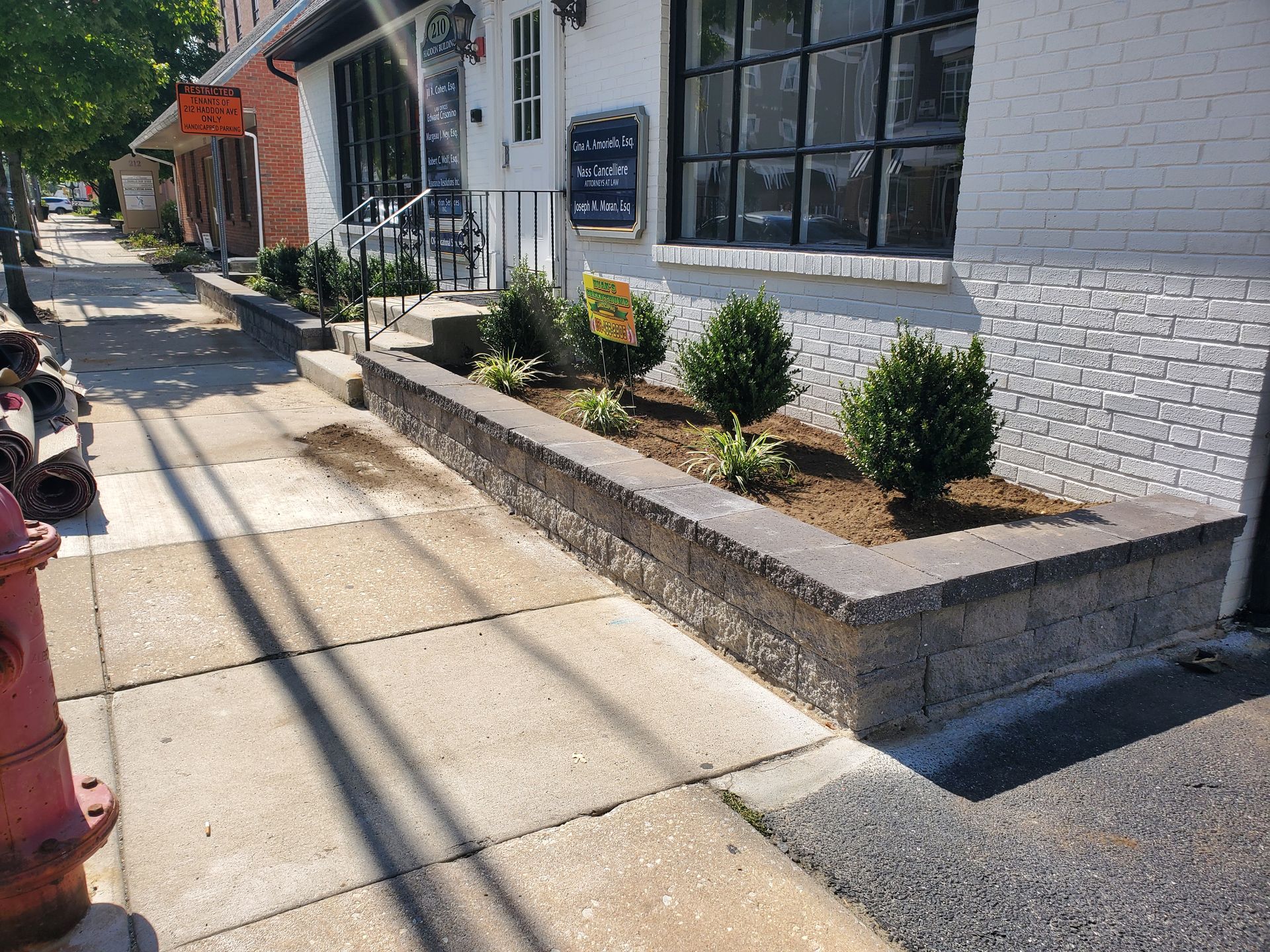 A garden with lots of flowers and plants in front of a building.