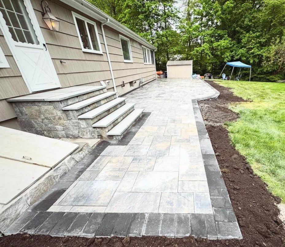 New stone walkway and steps alongside a house with fresh landscaping